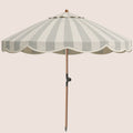 A classic patio umbrella with alternating light beige and green greyvertical stripes, featuring a scalloped edge, a natural wood pole, and a metal tilt hinge