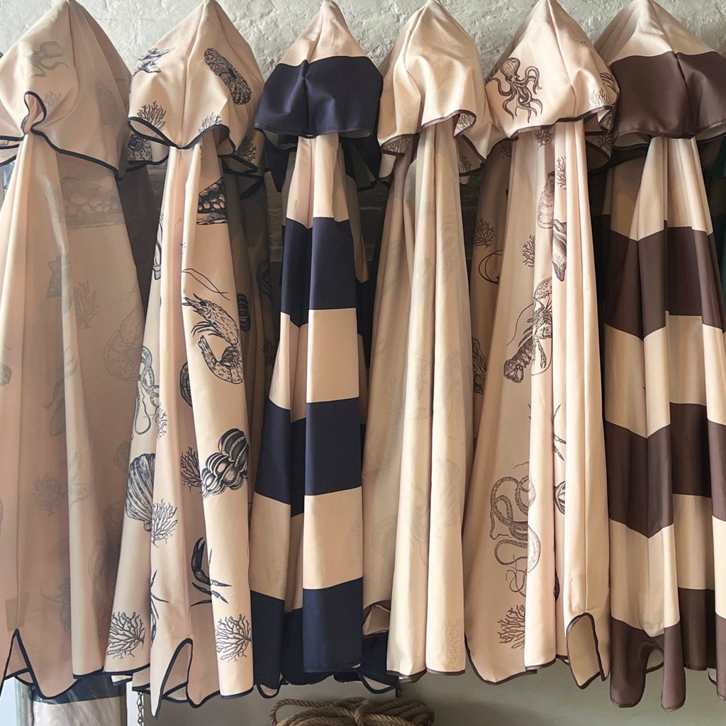 Harbour Bounty range of parasol designs. The canopies are hanging on a rustic rail
