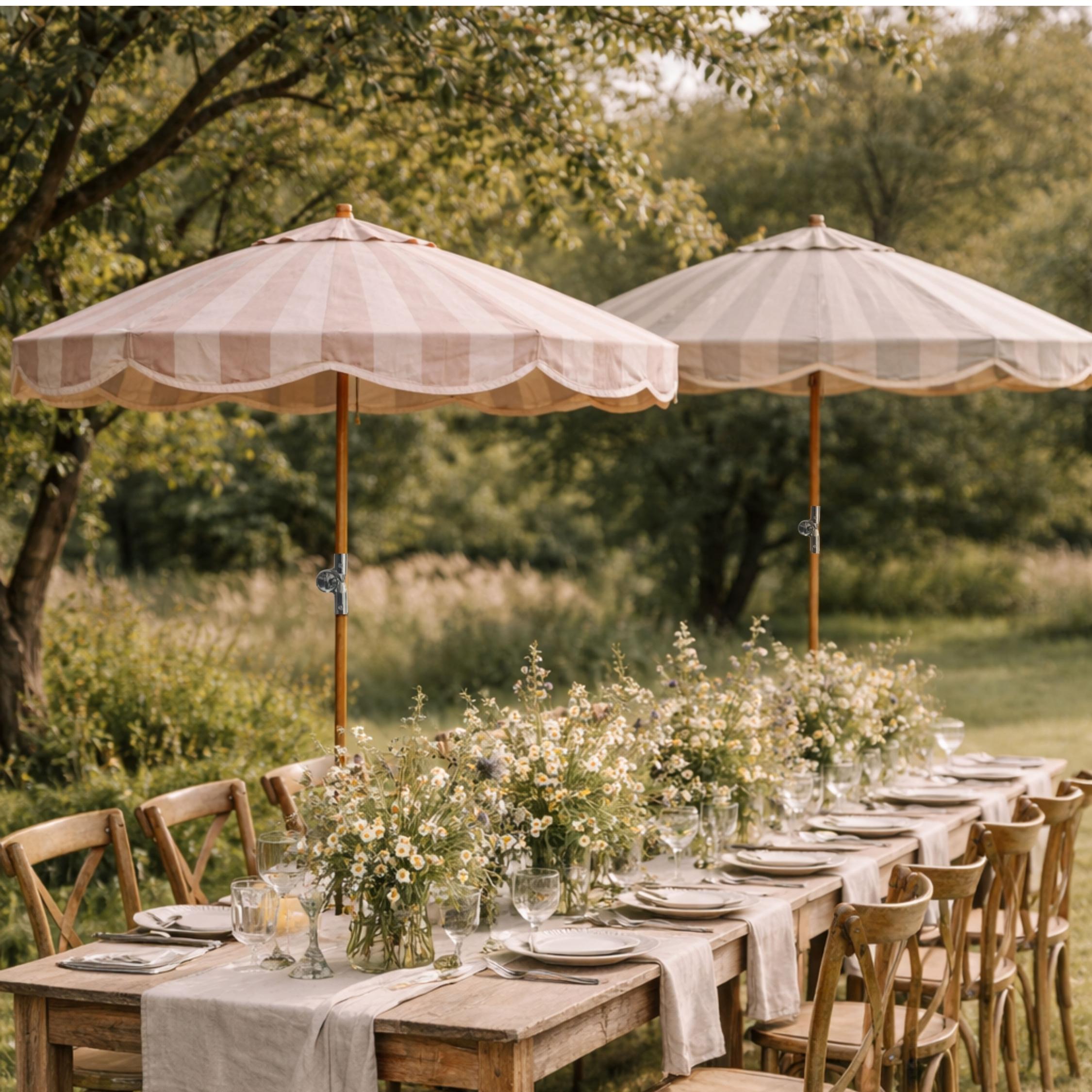 Pavilion striped garden parasols shading an outdoor dining table in a country garden.
