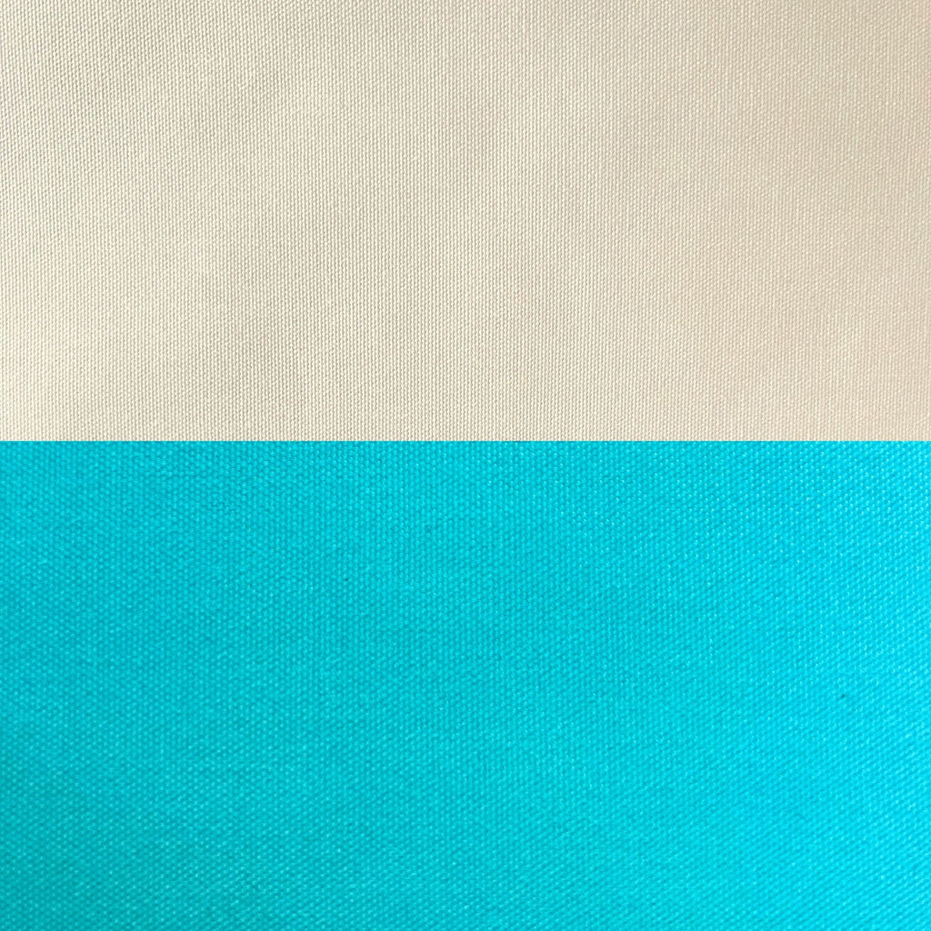 A close-up of a woven fabric texture split horizontally into two color blocks: a warm off-white/cream top half and a bright turquoise-blue bottom half.