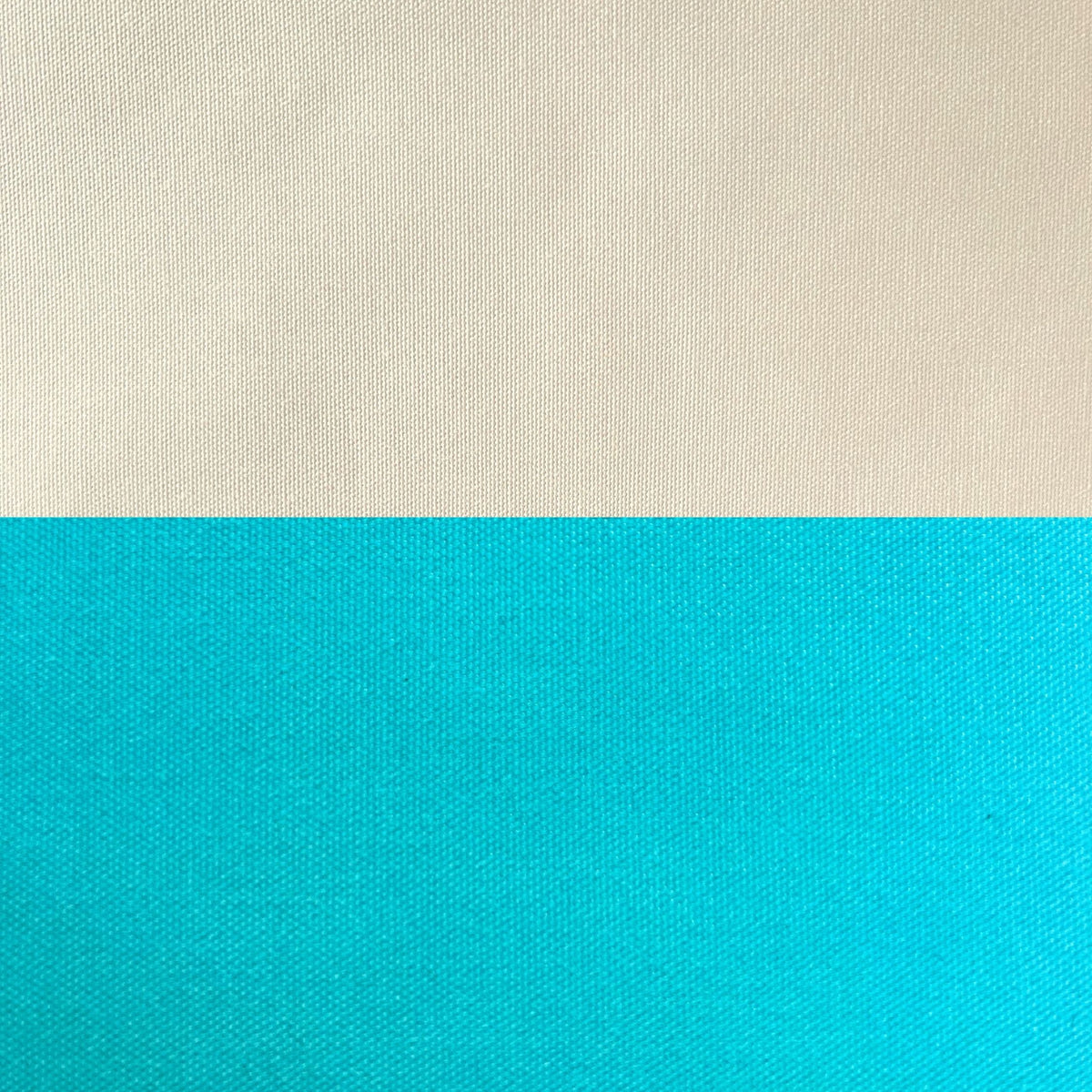 A close-up of a woven fabric texture split horizontally into two color blocks: a warm off-white/cream top half and a bright turquoise-blue bottom half.
